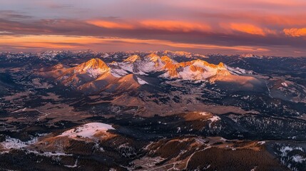 Fototapeta premium Sunset over snow-capped mountains, aerial view.