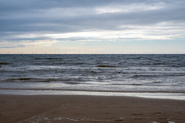 Sea with many wind turbines on the horizon