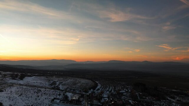 Drone view of ice-covered Sapareva Banya town at sunset with mountain in the background in Bulgaria