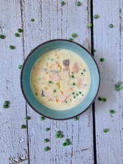 Salmon soup with peas and melted cheese
