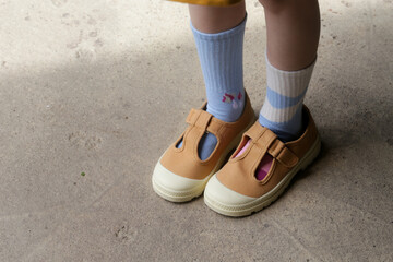 Kid wears different pair of socks. Child foots in mismatched socks, studio photography. Down...