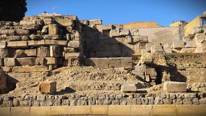 Fototapeta premium Majestic ruins of an ancient stone building, showcasing weathered walls and arches that hint at a rich historical past. The scene is filled with an aura of timelessness, blending nature and history in