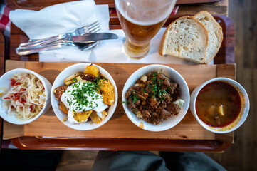 Budapest, Hungary. August 29,2022. Top view footage of an appetizing tasting tray of local delicacies, starting with goulash on the right and going to the left with other dishes with vegetables.