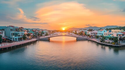 Fototapeta premium Sunset over a picturesque town with a bridge and calm water