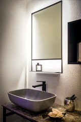 Modern bathroom interior showing illuminated mirror and sink