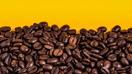 Close-up of roasted coffee beans on a vibrant yellow background, highlighting texture, richness, and coffee culture.