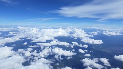 Aerial view of fluffy white clouds and blue sky.