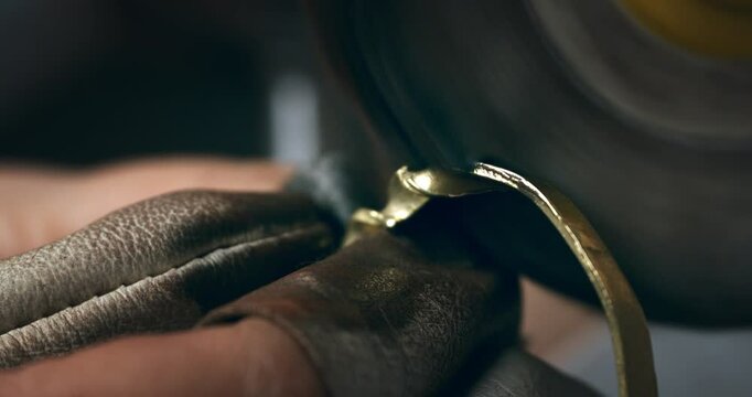 Super Slow Motion of Polishing Gold Jewelry Ring with Grinder Tool - Close-Up of Artisan Wearing Gloves and Using Rotary Machine to Finish Metal Surface at 1000 fps.