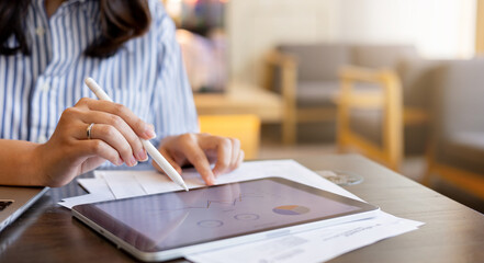 close up executive businesswoman hand using stylus pen to pointing on tablet screen to show company...