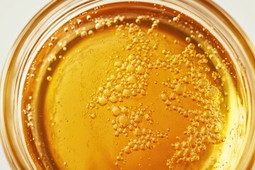 Close-up of golden, viscous liquid with numerous air bubbles suspended within.
