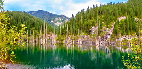 Sunken forest of Lake Kaindy in Kazakhstan. Beautiful mountain natural landscape. A blue lake with...