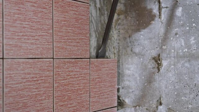 Builders remove old floor tiles with chisel, perforator and hammer, preparing surfaces for repair. Dust and debris accumulate in process of transforming spaces