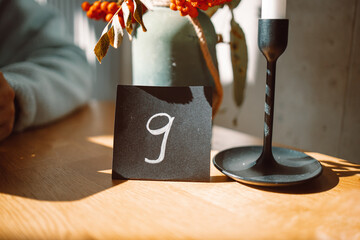 White color number nine sign of a black stand for ordering food placing on a wood table in a cafe