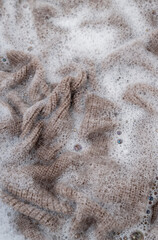 Close up of Light Colored Fine Merino Wool Sweater being Soaked in Delicate Wash 