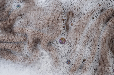 Close up of Light Colored Fine Merino Wool Sweater being Soaked in Delicate Wash 