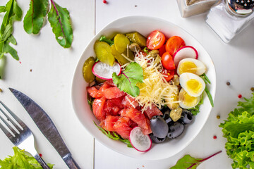 Bowl with tuna, quail eggs, cherry tomatoes, pickles cucumber, capers and black olives
