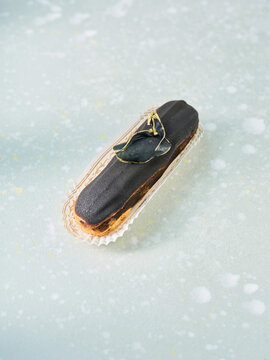 Delicious Modern Dessert With Striking Black and Gold Design Displayed on a Textured Surface