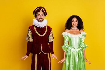 Elegant couple dressed in vintage royal costumes on vibrant yellow background for a themed party or carnival event