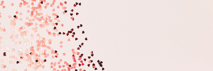 Banner with red confetti in a heart shape on a gray background.