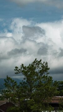 Vertical video - Timelapse of thick clouds rolling over the suburban area in Bandung, Indonesia