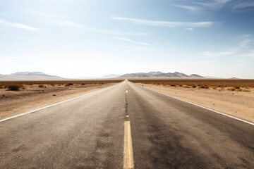 Long, empty road stretches out into the distance, with mountains in the background.