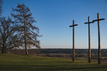 landscape with three crosses standing on the side of a cliff