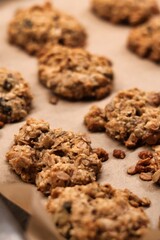 The process of preparing homemade oatmeal cookies - baked cookies placed on a baking tray lined with baking paper