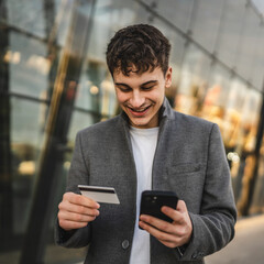 adult man use mobile phone and credit card for online shopping outdoor