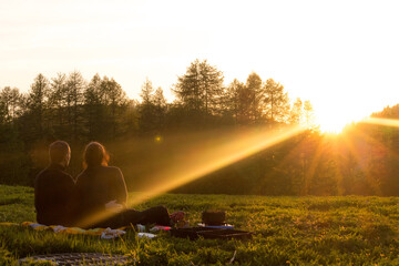 couple observant l'horizon et le coucher de soleil depuis un champs alpes maritimes