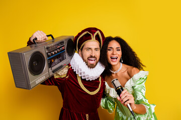 Cheerful Couple Posing in Elegant Historical Costumes Against a Bright Yellow Background