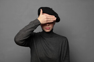 covering eyes with one hand feeling scared or anxious, wondering or blindly waiting for a surprise