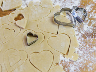 process of making heart-shaped valentine cookies and kitchen utensils