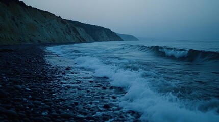 Fototapeta premium Serene twilight coastal scene, waves crashing on pebble beach near cliffs.