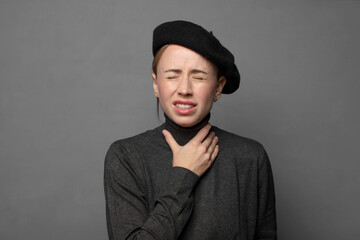 Obraz premium feeling ill with a sore throat and flu symptoms, coughing with mouth covered