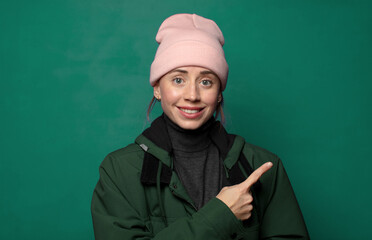 smiling cheerfully, feeling happy and pointing to the side and upwards, showing object in copy space