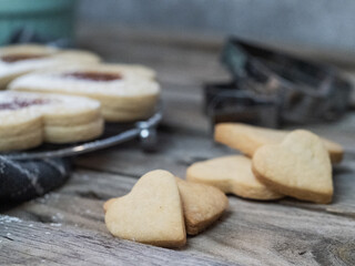 A plate of cookies. The cookies are heart-shaped and have powdered sugar on them