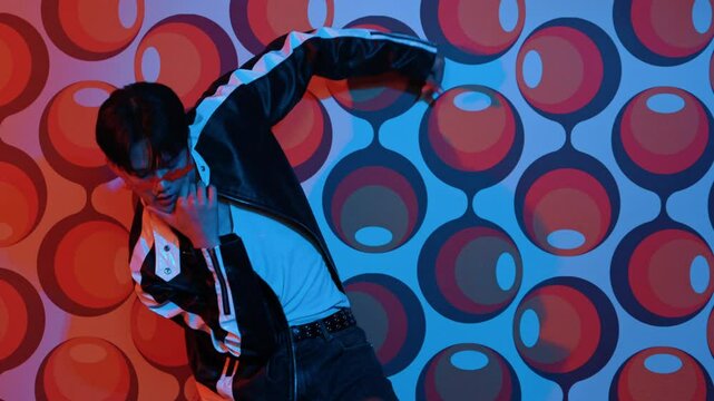 Caucasian dancer in causal shirt perform break dancing while standing at party stage. Professional hipster looking at camera while moving hand and stretch arm to lively and freestyle song. Regalement.