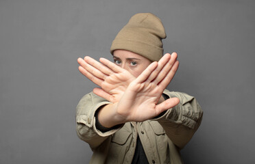 covering face with hand and putting other hand up front to stop camera, refusing photos or pictures
