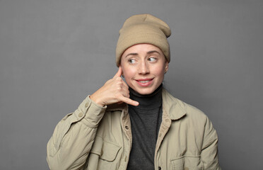 smiling cheerfully and pointing to camera while making a call you later gesture, talking on phone