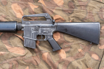 Old American made M16 rifle on a camouflage tarp