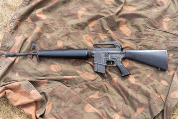 Old American made M16 rifle on a camouflage tarp