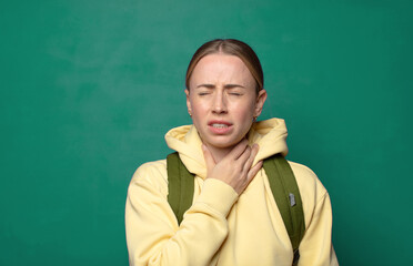 Fototapeta premium feeling ill with a sore throat and flu symptoms, coughing with mouth covered