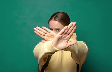 covering face with hand and putting other hand up front to stop camera, refusing photos or pictures