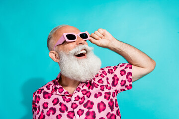 Photo of handsome bearded grandpa excited look empty space dressed stylish pink leopard print garment isolated on cyan color background © deagreez