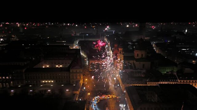 Aerial view at midnight of fireworks rockets and firecrackers in downtown Munich, Germany at Odeonplatz. Feldherrnhalle and Theatinerkirche in salute. Silvester Feuerwerk uber Munchen Luftaufnahme. 