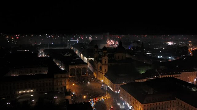 Aerial shot at midnight of fireworks and firecrackers lighting up downtown Munich, Germany, Odeonplatz. Feldherrnhalle and Theatinerkirche stand as part of festive scene. Silvester Feuerwerk Muenchen