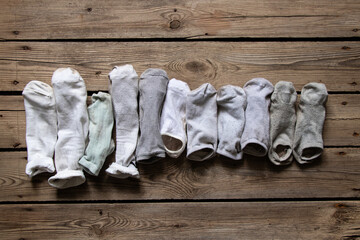 Many women's socks are folded and lying on a wooden floor