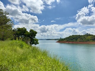 Fototapeta premium Lindo ceú azul com fundo para represa cheia de agua com cores vibrantes da natureza.