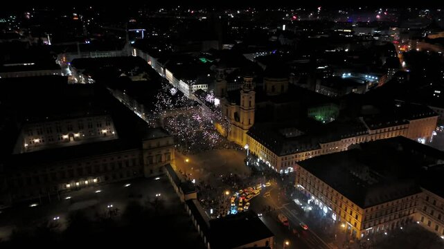 Aerial shot at midnight of fireworks and firecrackers lighting up downtown Munich, Germany, Odeonplatz. Feldherrnhalle and Theatinerkirche stand as part of festive scene. Silvester Feuerwerk Muenchen