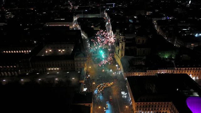 Aerial view at midnight of fireworks rockets and firecrackers in downtown Munich, Germany at Odeonplatz. Feldherrnhalle and Theatinerkirche in salute. Silvester Feuerwerk uber Munchen Luftaufnahme. 